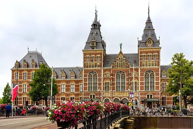 The red-brick Rijksmuseum with its two towers seen from a bridge, with flower boxes in the foreground